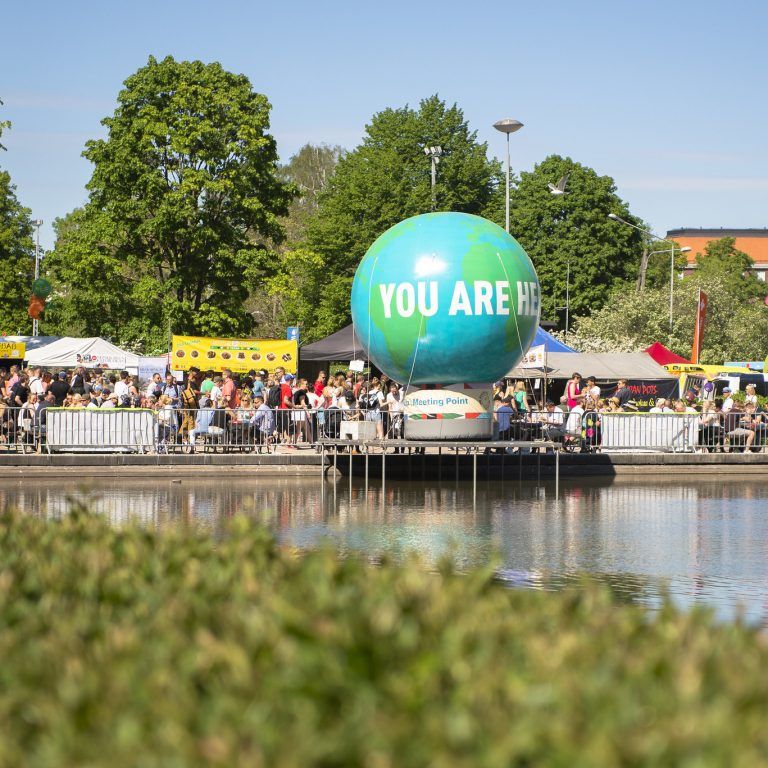 Picture of a large globe decoration in the Word Village Festival area. Text "You are here" is written on the globe.