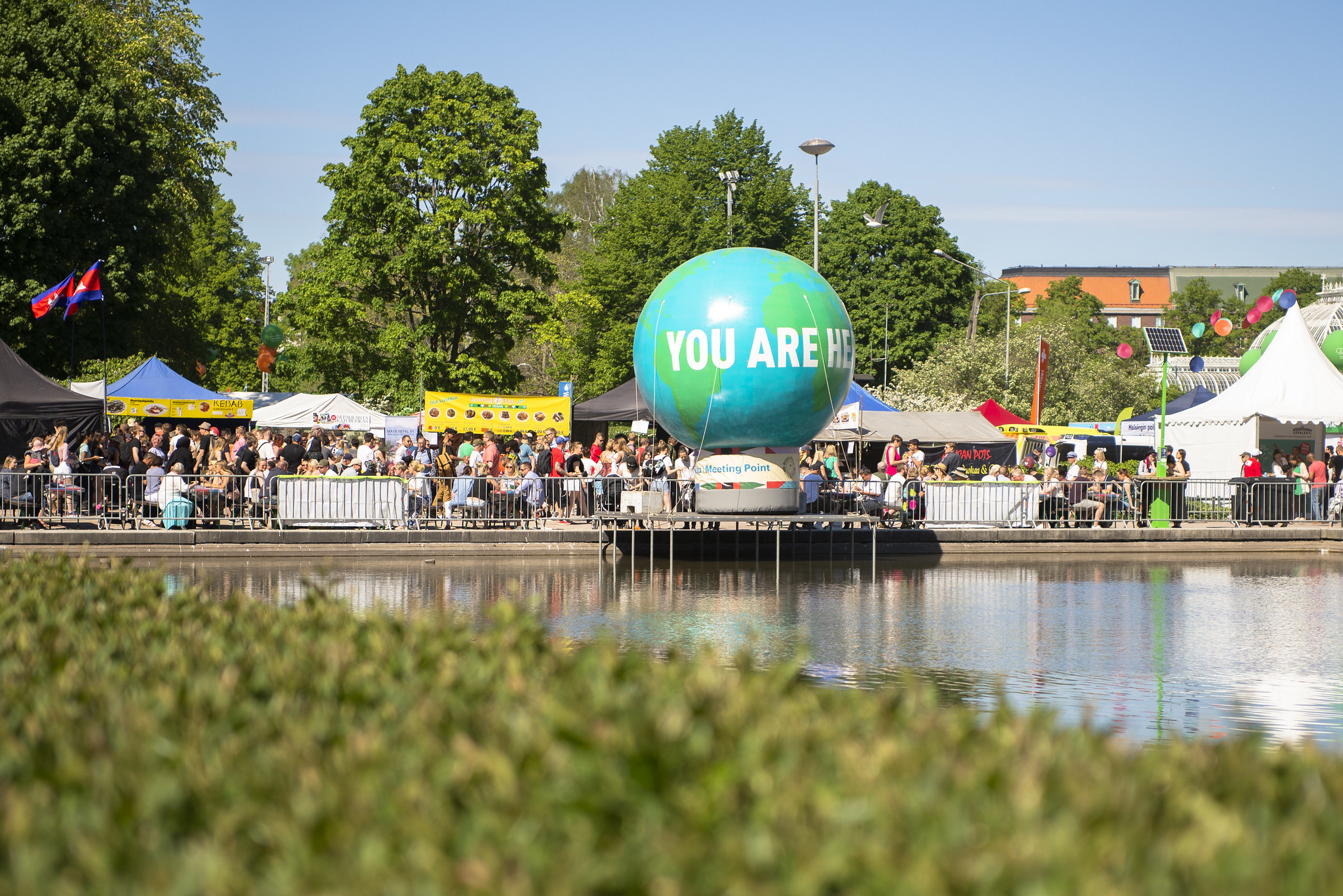 Kuva suuresta maapallokoristeesta Maailma kylässä -festivaalialueella. Pallossa lukee "You are here".