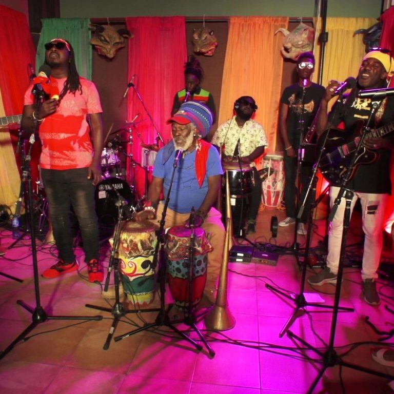 Lakou Mizik performing at the festival. 8 musicians in a colorful room.