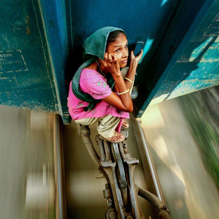 Kuvassa nainen matkustaa junavaunujen välissä.