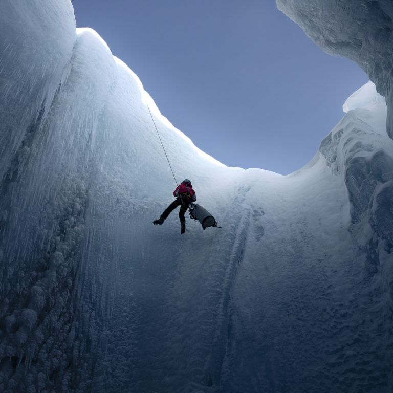 Kuvassa tutkija Alun Hubbard laskeutuu jäätikkökaivoon.