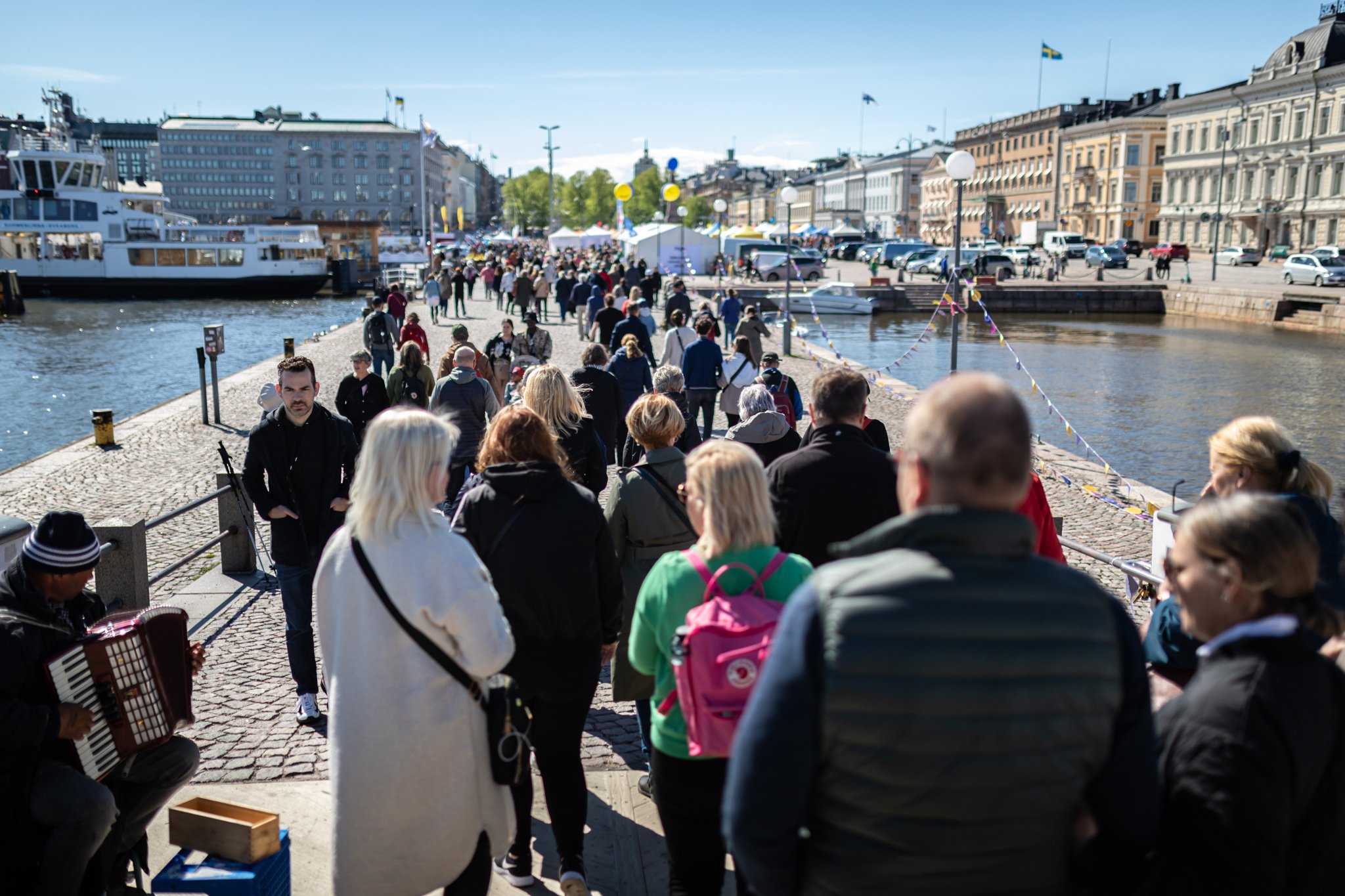 People walking towards the Market of Possibilities on a bridge at Kauppatori, Helsinki.