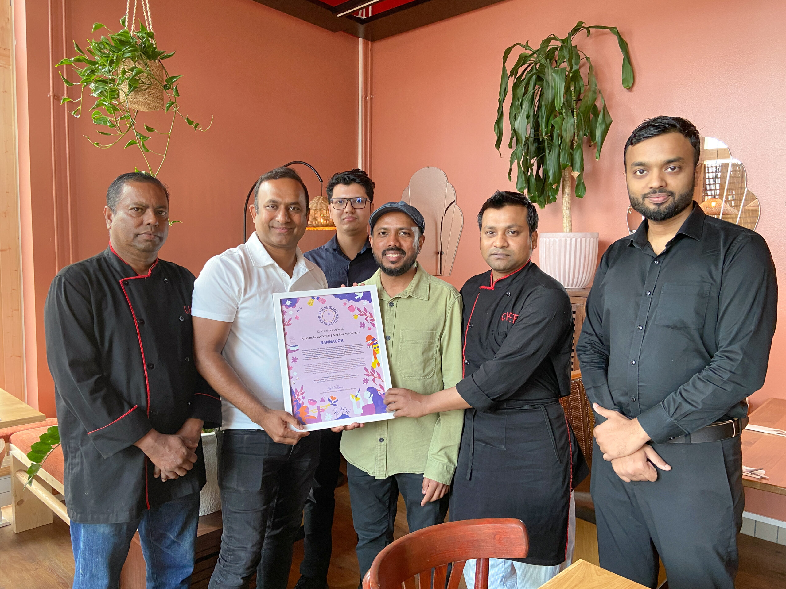 In a group photo, the restaurant's staff with a framed diploma.