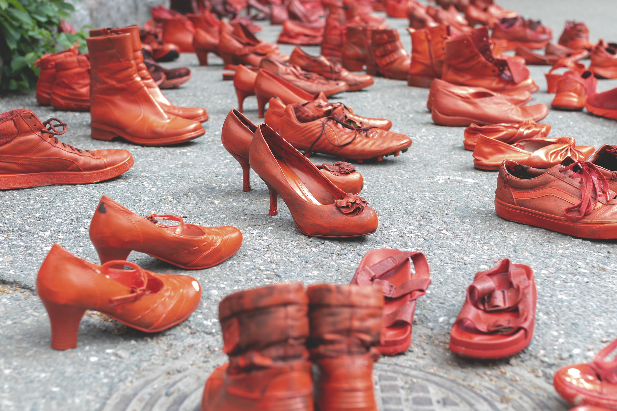 Red painted shoes on asphalt.